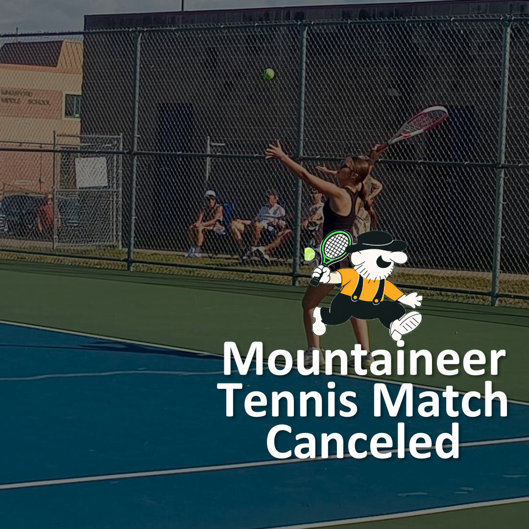 Graphic with dark overlay and white text: "Mountaineer Tennis Match Canceled." Features the Iron Mountain Mountaineers mascot—a caricature with a black hat, yellow shirt, and suspenders—holding a tennis racket, superimposed over a photo of a tennis player swinging a racket on a court. Background Image: A high school tennis match in progress on an outdoor blue and green hardcourt surrounded by a chain-link fence. A player in a black tank top is in mid-swing raising a racket toward a floating tennis ball, with spectators sitting on benches in the background.